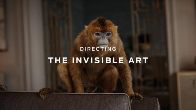 A animated life-like monkey from His Dark Materials with white text over the centre. 