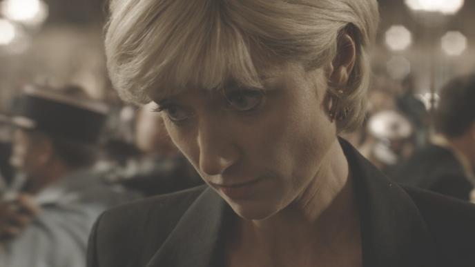 Elizabeth Debicki, playing Princess Diana looking down as paparazzi take photos