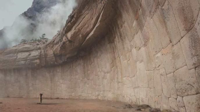 Concept art from Paddington in Peru. Paddington looks up at a large imposing stone wall