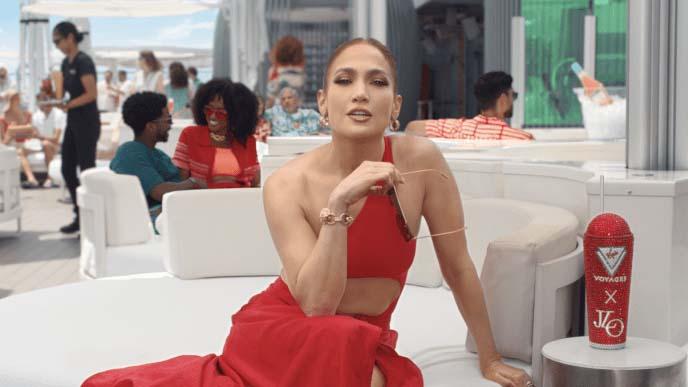 Still of J.Lo in red dresssitting facing the camera