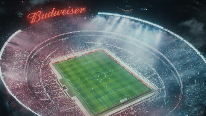 A soccer/football stadium with a large CG Budweiser sign. The stadium is packed with a large crowd (which has been made by VFX Crowd Simulation) 
