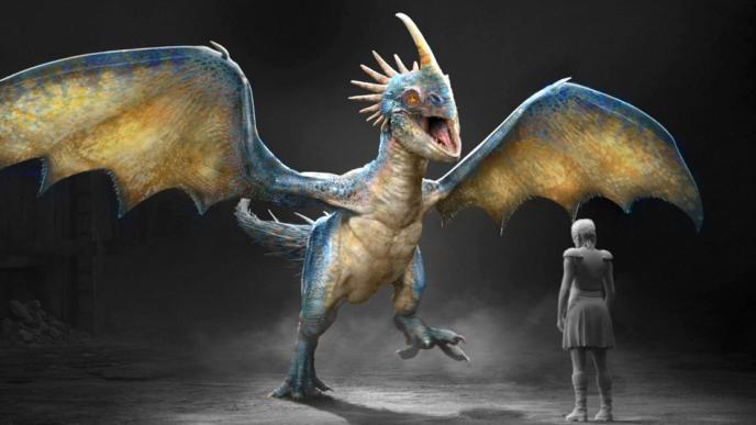A large spikey illustrated concept design of a dragon from How to Train Your Dragon standing in front of a person. 