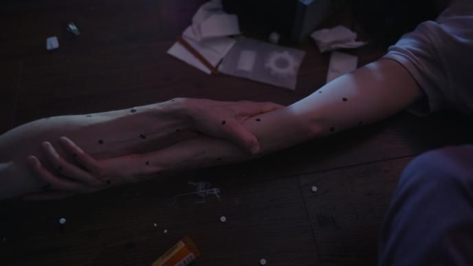 Close up shot of Millie and Tim's arms fusing together 