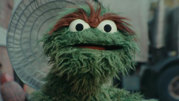 Oscar the Grouch looks onward from his garbage can