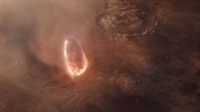 A space ship on fire barrels down towards an orange planet