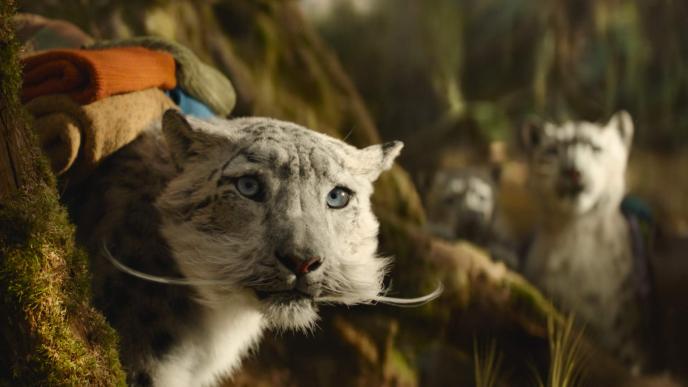 CGI animated snow leopard family in Wicked: For Good, wearing their belongings on their back