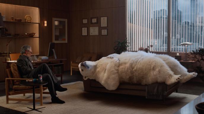 A CG animated polar bear lays on a therapists couch, his therapist (played by Taika Waititi) sits across sitting on a chair