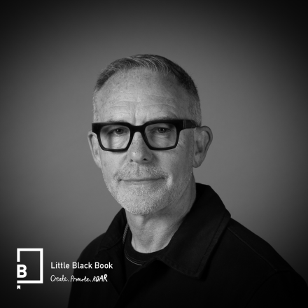 A photograph of Mike McGee against a grey background with the Little Black Book logo in the bottom left hand corner.