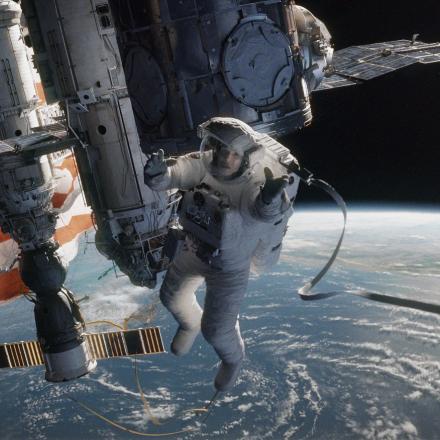 A Still from the film Gravity showing Sandra Bullock's character in space above a space station.