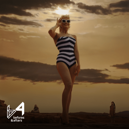 A still from the film Barbie showing Margot Robbie as a giant Barbie looking over a wasteland.