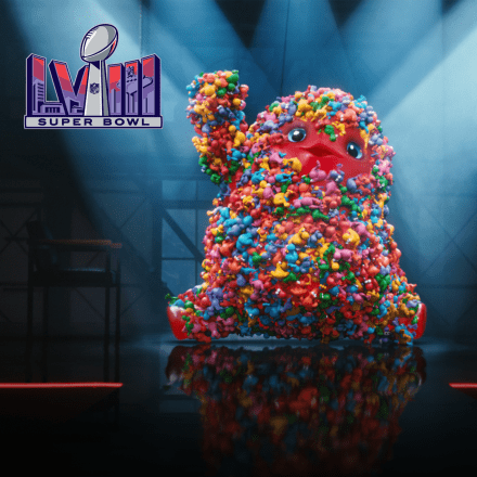 A giant red gummy Monster covered in Nerds dances on stage
