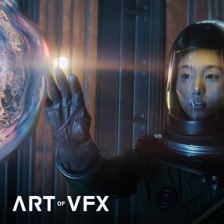 A woman in a space suit with her hand outstretched reaching towards a iridescent floating alien.   