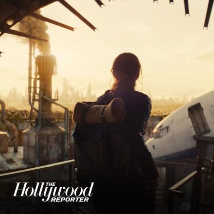 A silhouette of a woman looking out over a destroyed landscape.