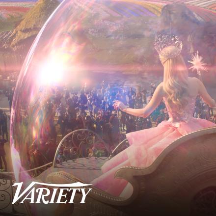 A woman wearing pink floating inside a pink bubble over the top of a crowd.
