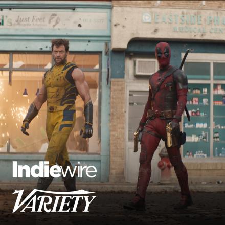 Two mean wearing superhero outfits walking around a corner.