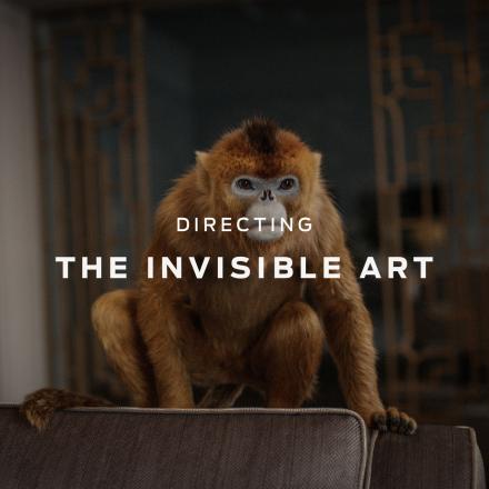 A realistic CGI golden monkey sat on a chair with the text Directing the Invisible Art overlaid in white.