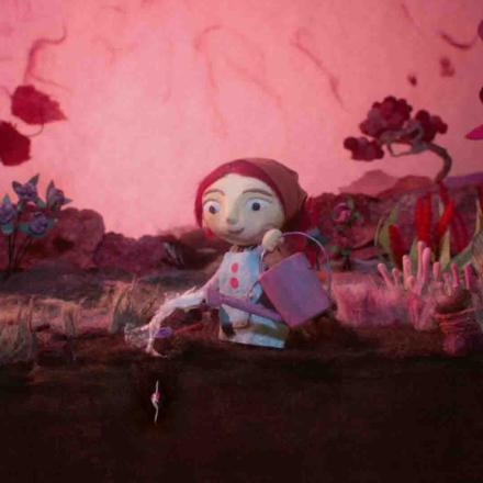 A still from the Womb Stories advert. A woman waters a garden using a watering can.