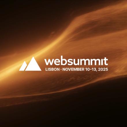 A dark background with a sweep of CGI dust and fire across the middle and a white Web Summit logo