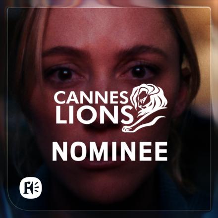 A shot of a woman's face lit with pink light, there is a white Cannes Lions logo in the centre.
