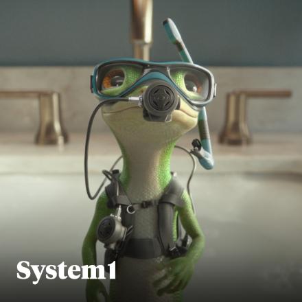 The CG animated GEICO gecko wearing scuba goggles, snorkel, and diving gear, standing indoors with a confident expression against a softly blurred background.