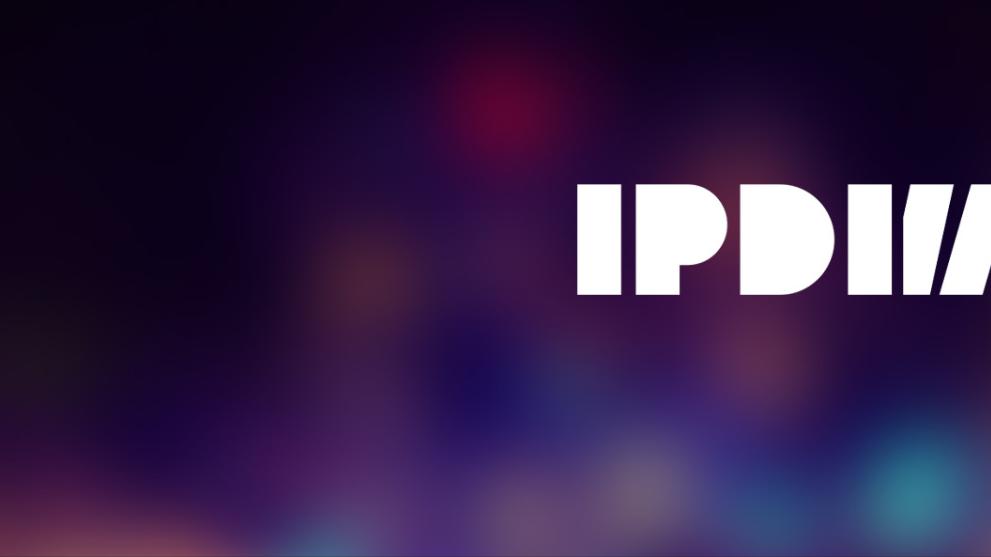 A multicoloured soft background with a white International Production Design Week logo.