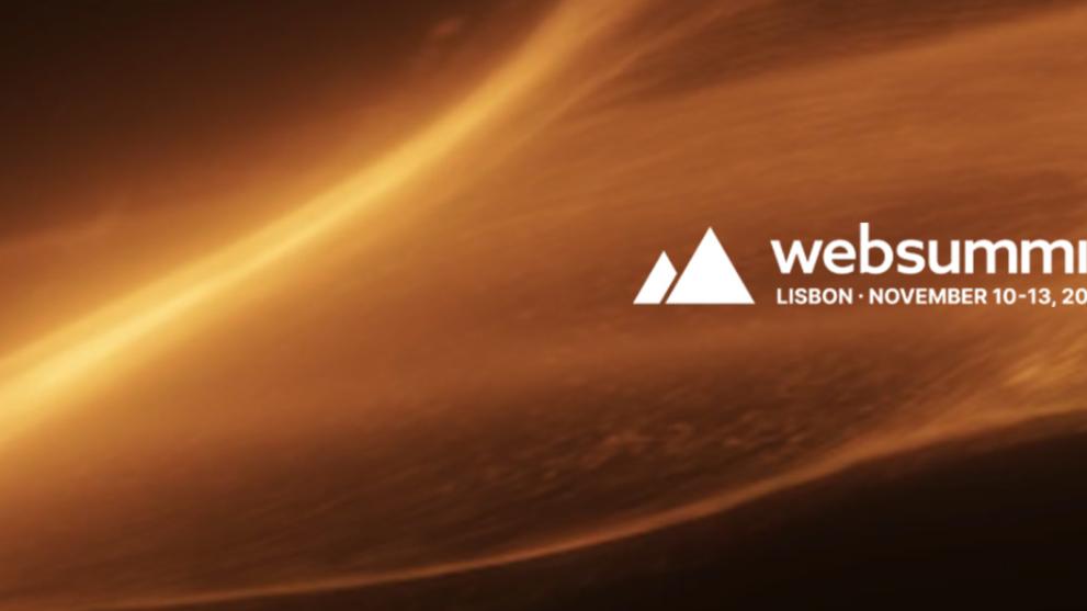 A dark background with a sweep of CGI dust and fire across the middle and a white Web Summit logo